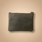 Dark leather pouch with a zipper on a light gray background