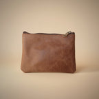 Brown leather pouch on a light gray background