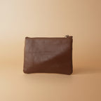 Brown leather pouch on a light gray background