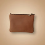 Brown leather pouch with a zipper on a light gray background