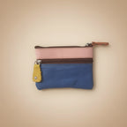 Small blue pouch with pink and brown accents on a light gray background