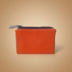 Orange leather wallet with a zipper on a light gray background
