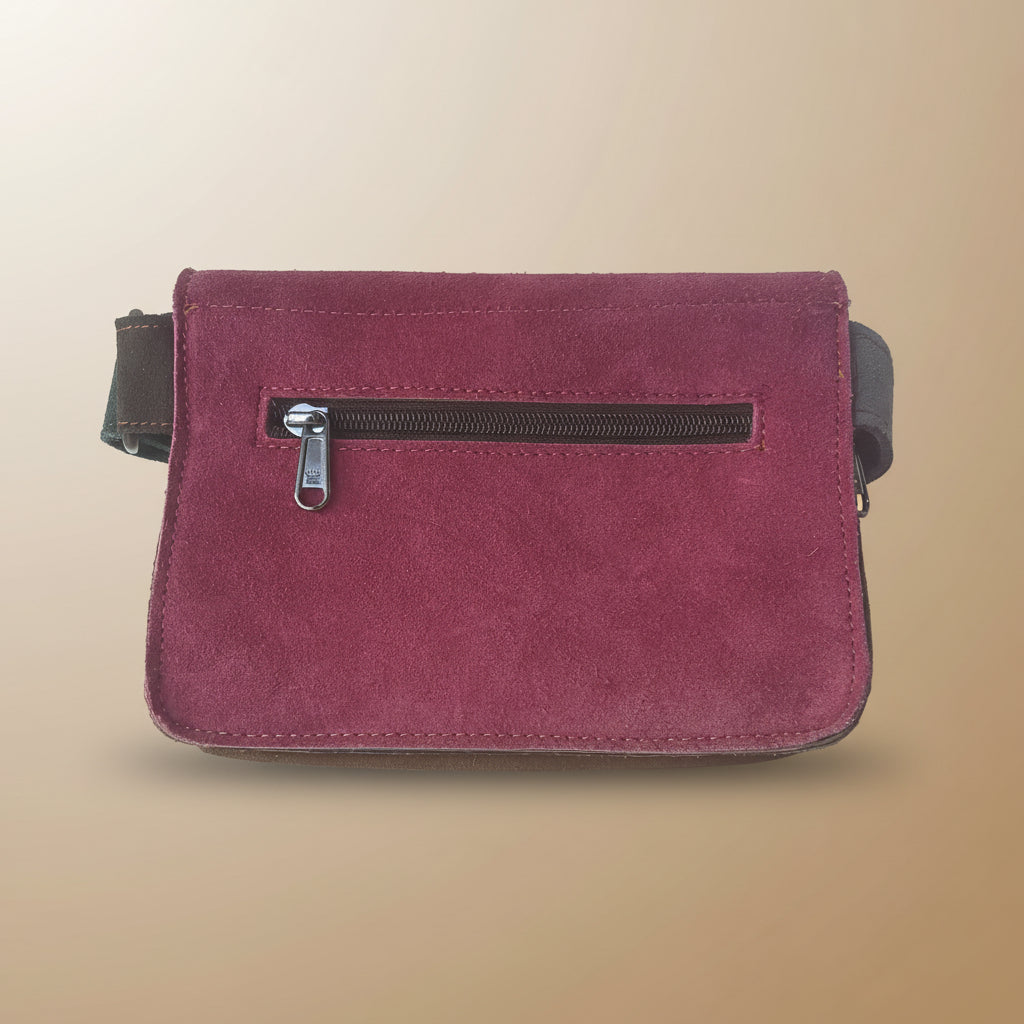 Maroon wristlet with a zipper on a light gray background