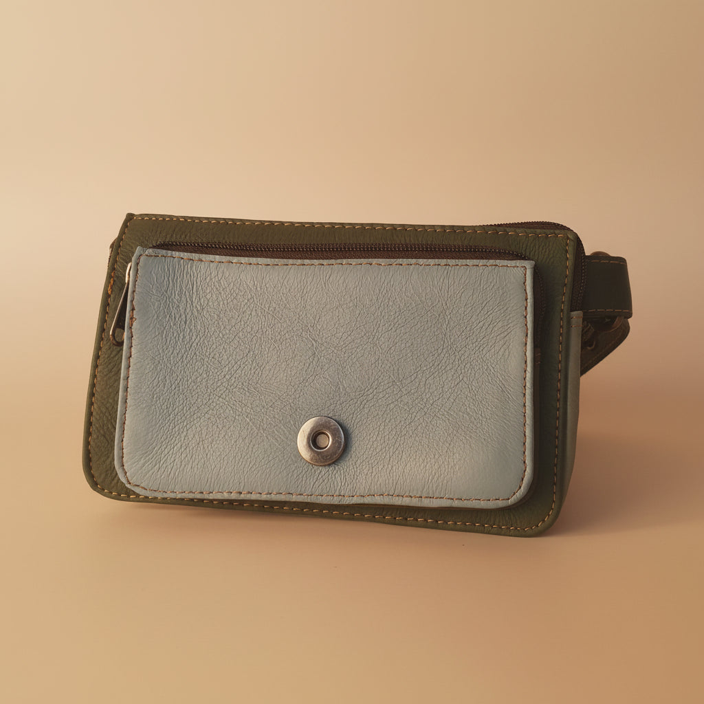 Blue leather crossbody bag with strap on a light gray background