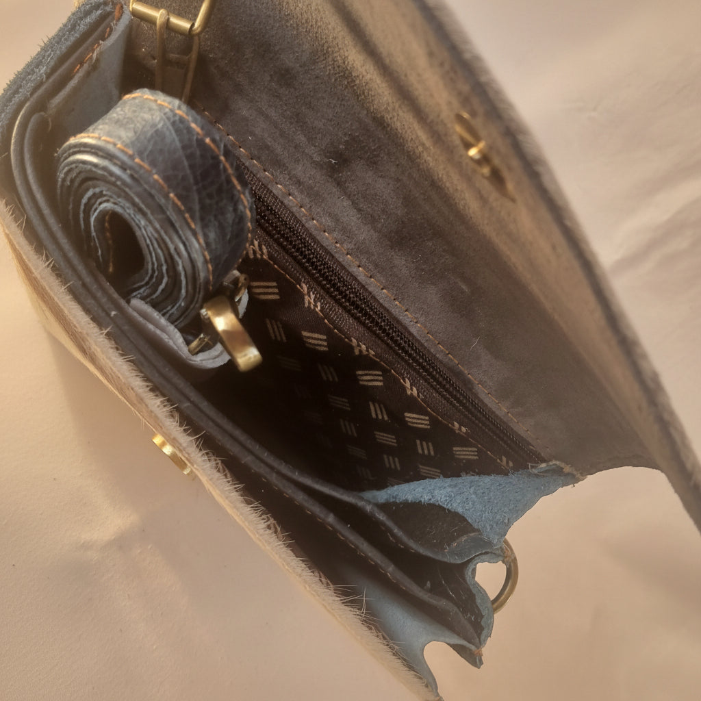 Close-up of a blue denim pouch with a zipper on a light gray background