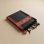 Black and red woven fabric with fringes on a beige background