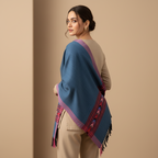 Woman wearing a blue and pink patterned shawl on a beige background