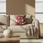 Beige sofa with a colorful floral pillow and a blanket in a modern living room.