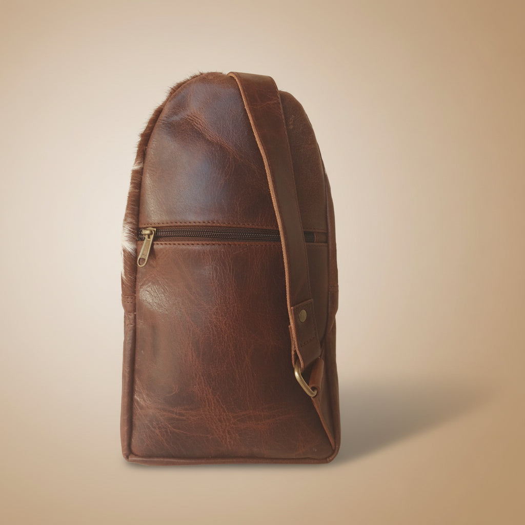 Brown leather bag with strap on a white background