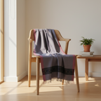 Wooden chair with a patterned blanket draped over it in a bright room.